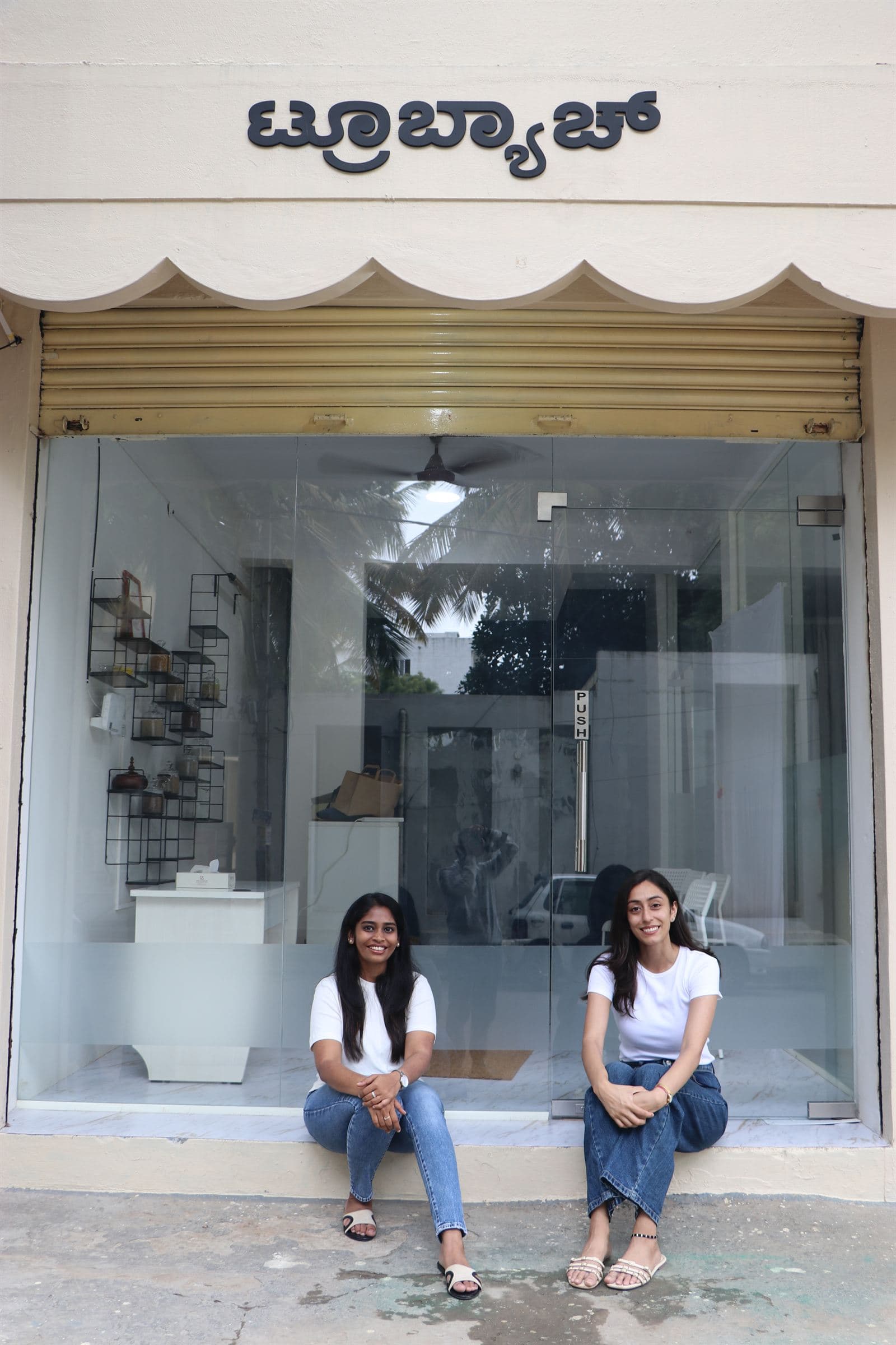 Ramya and Akriti seated outside the TrueBatch mill in Jakkur